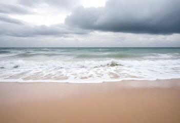 Fototapeta na wymiar Sandy beach with gentle waves and a cloudy sky