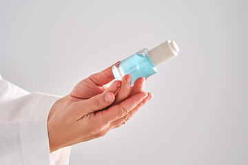 Blue serum with pipette in a womans hands in a robe.