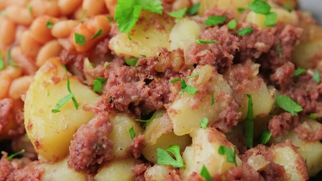 Corned beef hash with potatoes and beans in tomato sauce. Rotating video