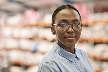 Confident young African woman standing in a large warehouse