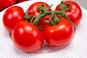 Red ripe tasty Dutch tomatoes growing indoor in greenhouse all seasons, food industry in Netherlands close up