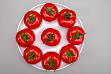 Red ripe tasty Dutch tomatoes growing indoor in greenhouse all seasons, food industry in Netherlands close up