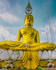 Big Golden Buddha statue against blue sky in Thailand temple
