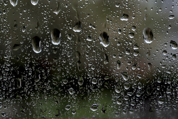 Rainy background with water drops on window glass