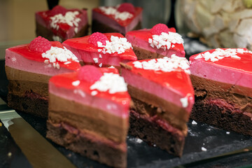 a display of slices of chocolate and raspberry desserts