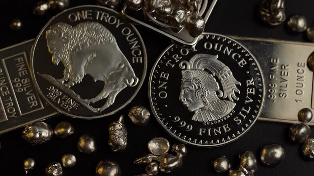 Silver bars and silver coins of precious metal spinning round
