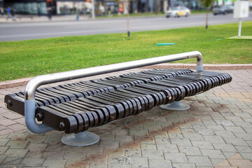 Outdoor bench with metal railing on brick sidewalk