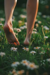 female legs standing barefoot in a field with green grass and daisies, concept of freedom and happiness