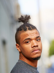 Portrait, black man and cool or funky hairstyle in city with topknot and braided hair for...