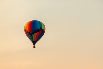 One colorful hot air balloon on the right side of a clear sky.