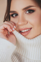 Young woman covering face with sweater collar