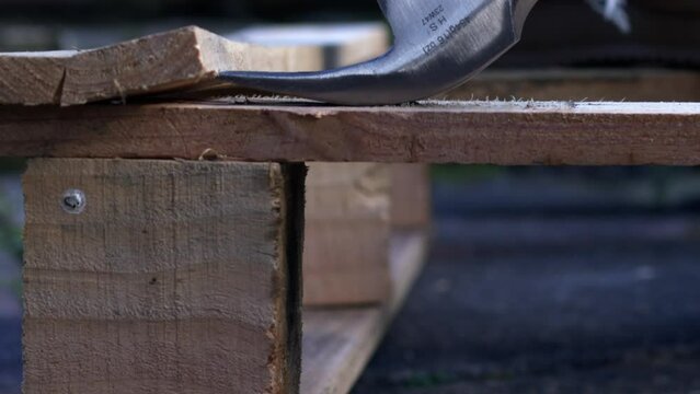 Work boots with recycling wooden industrial pallet with a hammer background