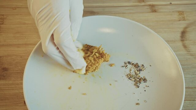 Grating fresh turmeric, curcumin. curcuma on a metal grater, on a white plate with rubber gloves. Natural spices, herbs. Close up. High quality 4k footage