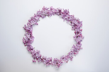Round frame of lilac flowers isolated  on a white background. Top view, flat lay. Space for text.