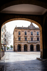 In Gijón's deserted urban setting, an architectural arch offers a window to its soul.