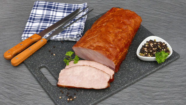 Kasseler Lachsbraten: Ger&auml;ucherter Schweiner&uuml;cken auf einem K&uuml;chenbrett.