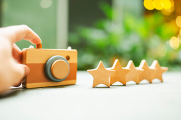 A reviewer is holding a toy camera with 5 wooden star models. Ideas for rating and reviewing...