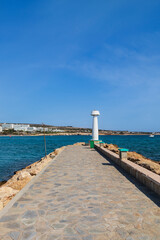 Obraz premium Pier landscape with a white lighthouse. Ayia Napa Harbour pier in Cyprus overlooking the Mediterranean Sea
