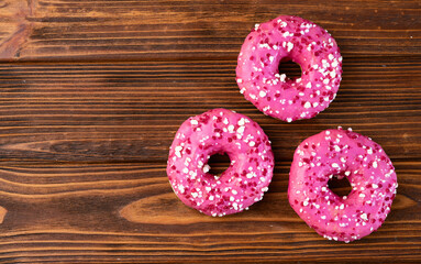 Set of colorful donuts on wooden background