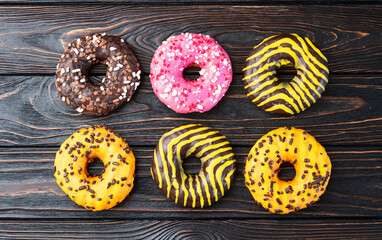 Set of colorful donuts on wooden background