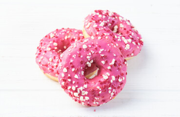 Set of colorful donuts on wooden background