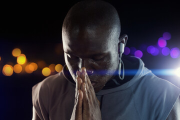 Black man, athlete and praying hands for sports exercise at night with bokeh for competition, hope...