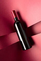 Bottle of red wine on a red background. - 787408117