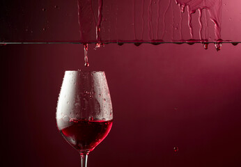 Red wine flows down into a glass. - 787408189