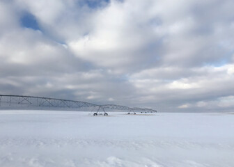 Irrigation pivot equipment in a snow covered field on a bight day