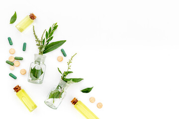 Alternative herbal medicine concept with healing herbs and essential oil in glass bottles