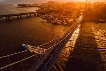 Cable bridge with sunset light and touristic boat in Florianopolis, Brazil. Aerial view - 787411996