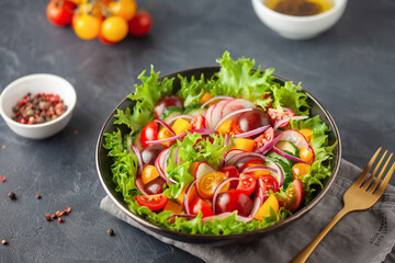 Easy vegetarian salad of fresh cucumber, tomato, sweet pepper, radish and onion . Healthy food.