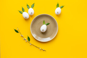 Easter decoration with eggs in shape of bunnies made of spring leaves and willow bud, with willow...