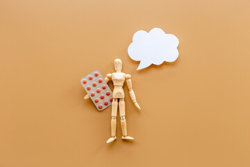 Wooden dummy man with medical pills. Medicine and healthcare concept
