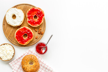 Baked bread bagels with with berry jam and cheese cream. Healthy breakfast background