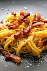 Piatto di deliziosi e cremosi spaghetti alla carbonara, una ricetta tipica di pasta della cucina Romana con tuorlo d'uovo, guanciale, pecorino e pepe nero, cibo italiano  - 787424319