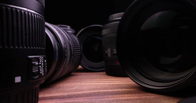 Very close-up of photo camera and video camera lense isolated on a black background in slow motion.