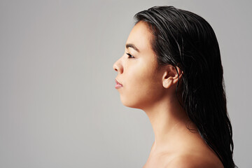 Woman, profile and haircare with salon cosmetics, skincare or beauty on a gray studio background....