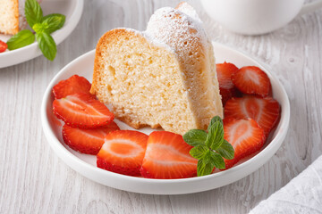 Piece of cupcake with strawberries on a plate