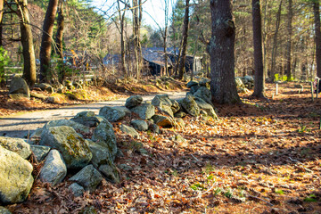 stone wall and rustic cabin on a dirt road