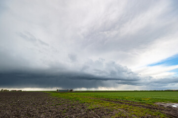 Storm cloud over plain farmland