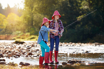 Countryside, activity and children fishing in river on holiday break, vacation or adventure as...