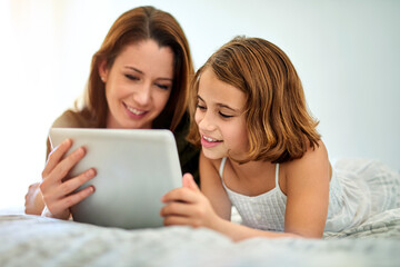 Smile, mother and child on tablet in bed at home together for game, relax and family streaming movie. Happy girl, mom and technology in bedroom for learning, education or reading ebook on app online