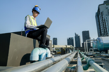 Site engineer with laptop communicating on construction site against a backdrop of the urban...
