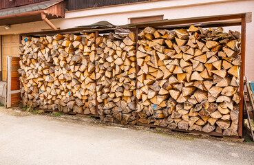 Stack of split firewood seasoning outside for sustainable energy for use in a wood stove