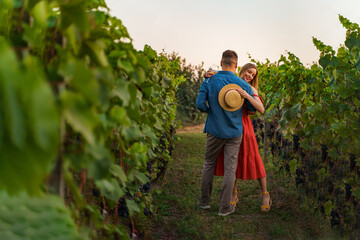 Young smiling couple tasting wine at winery vineyard