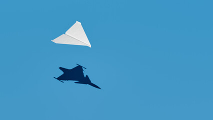 Fototapeta na wymiar Paper airplane with shadow of military aircraft, origami, blue background