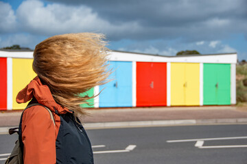 A woman with her hair blowing on a very windy day. Weather image of extreme weather. 