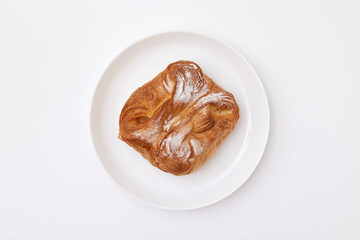 Sweet puff pastry with sour cream at a round plate isolated at white background. Pastry image.