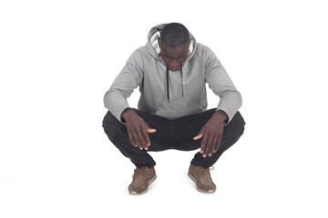 front view of man squatting and looking down on white background - 787443176